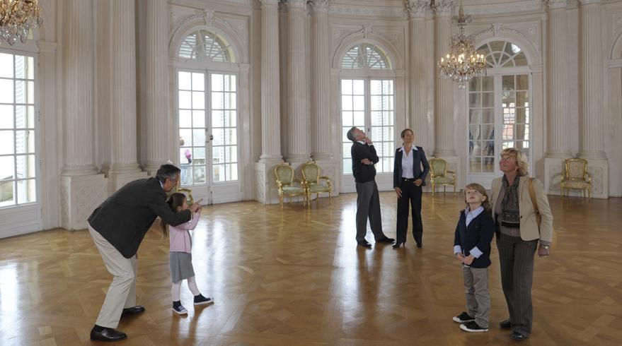 Besucher erkunden den Weißen Saal im Hauptgeschoss von Schloss Solitude