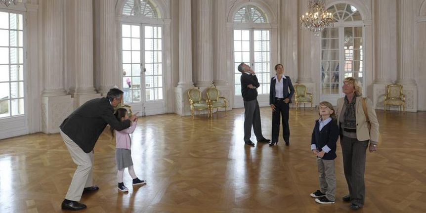 Besucher erkunden den Weißen Saal im Hauptgeschoss von Schloss Solitude